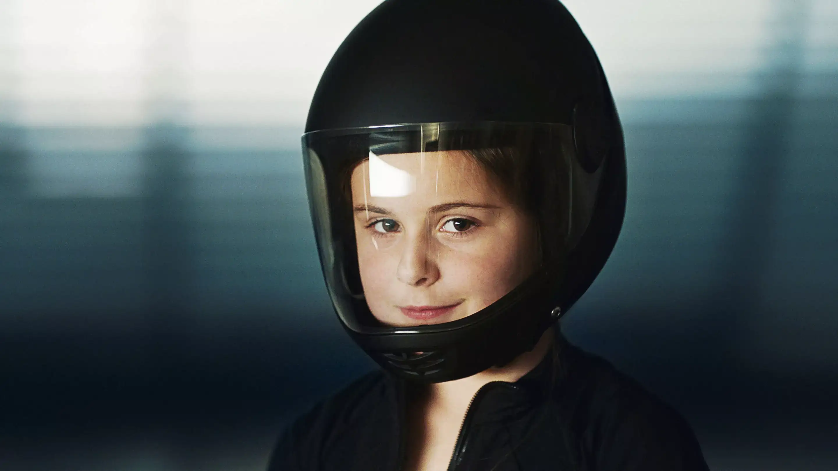 Young child flying in an iFLY tunnel with helmet on