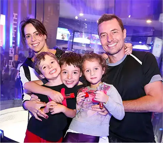 happy family smiling for a picture in front of the wind tunnel